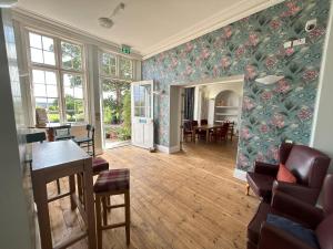 una sala de estar con una pared de papel pintado con motivos florales en YHA Whitby en Whitby