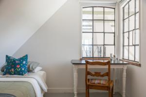 a bedroom with a bed and a desk next to a window at Villa Verde Österlen in Glemminge +53 photos