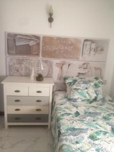 a bedroom with a bed with a dresser and a night stand at Maria Guest house in Albufeira