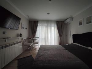 sypialnia z łóżkiem, stołem i oknem w obiekcie Urban Studio - Self Check-in w mieście Hunedoara