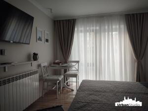 a bedroom with a bed and a table and a window at Urban Studio - Self Check-in in Hunedoara