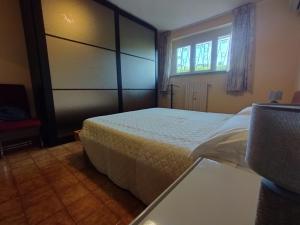 Un dormitorio con una cama grande y una ventana en Villa Azzurrina en Filettole