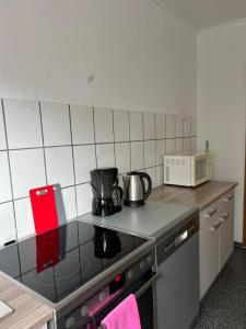uma cozinha com fogão forno ao lado de um micro-ondas em F&M Wohnungen in Olpe em Olpe