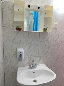 lavabo blanco en el baño con espejo en Ličke noći en Donji Lapac