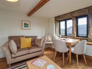 ein Wohnzimmer mit einem Sofa und einem Tisch in der Unterkunft Weaver's View in Hebden Bridge