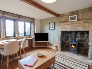 a living room with a fireplace and a television at Weaver's View in Hebden Bridge