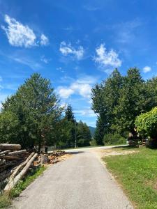 un camino de tierra con árboles y un cielo azul en Ličke noći en Donji Lapac