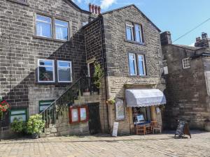 a brick building with a table and chairs in front of it at Weaver's View in Hebden Bridge