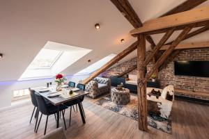 a living room with a dining table and a brick wall at CREST - Riverside Lofts mit Whirlpool & Wanne I Parken I Balkon I Netflix I Küche in Passau