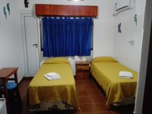 a room with two beds and a blue curtain at Hotel Brisas Marinas in San Clemente del Tuyú