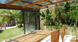 eine Terrasse mit einem Holztisch im Garten in der Unterkunft Bambou house in Cabriès
