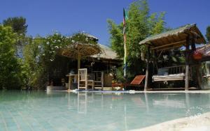 ein Resort mit einem Pool mit Stühlen und Sonnenschirmen in der Unterkunft Bambou house in Cabriès