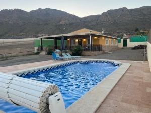 uma piscina em frente a uma casa com montanhas em Casa Rural Aguilas (Murcia), Venta San Felipe em Águilas