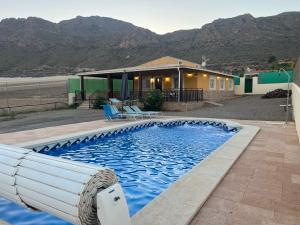 ein Schwimmbad vor einem Haus mit Bergen in der Unterkunft Casa Rural Aguilas (Murcia), Venta San Felipe in Águilas