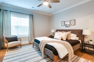a bedroom with a bed and a chair and a window at Cozy South Carolina Abode - Steps from Main Street in Greenville