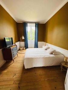 um quarto com uma cama branca e uma janela em Maison de Maître -Piscine-15 P em Basse-Goulaine