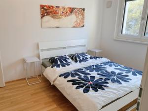 a bedroom with a bed with a blue and white comforter at U1 Alte Donau old Danube city apartment 2 in Vienna