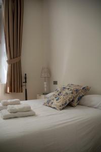 uma cama com lençóis brancos e toalhas em Apartamento Spinola Home em Sevilha