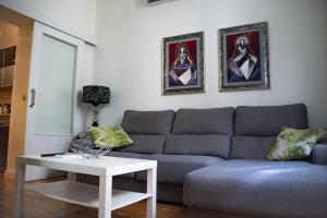 uma sala de estar com um sofá e uma mesa em Apartamento Spinola Home em Sevilha