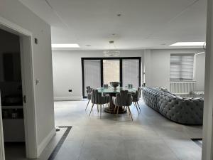 a dining room with a table and chairs and a couch at A super luxury large apartment in Barnet