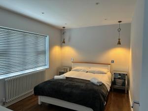 a bedroom with a bed and a large window at A super luxury large apartment in Barnet