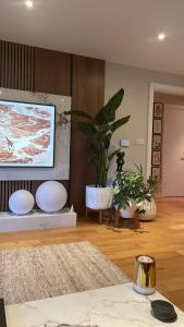 a living room with a flat screen tv on a wall at Cosy bedroom in Luxury apartment in London