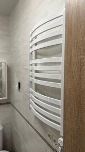 a bathroom with a wall with a stack of white towels at Japandi apartamentai in Kaunas