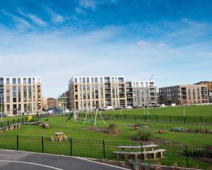 a park in a city with buildings in the background at Cosy bedroom in Luxury apartment in London
