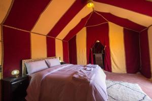 a bedroom with a bed in a tent at Merzouga Luxury Camping in Merzouga