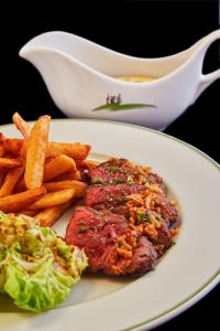 une assiette de nourriture avec un steak et des frites dans l'établissement Hôtel Golf Château de Chailly, à Chailly-sur-Armançon