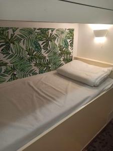 a bed in a small room with a wall with avertisement at Appartement avec piscine in Cavalaire-sur-Mer