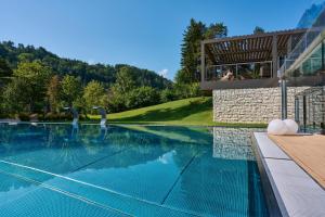 a swimming pool in front of a house at Grand Hotel Terme Di Comano in Comano Terme