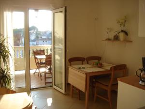 een keuken met een tafel en stoelen en een balkon bij Villa Delina in Rab