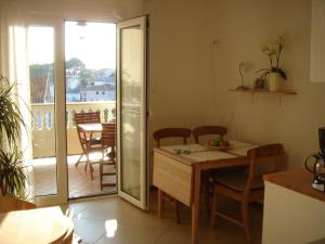 a kitchen with a table and chairs and a balcony at Villa Delina in Rab +54 photos