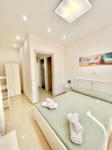 um quarto com uma cama com toalhas brancas em Casa vacanza l’archetto em Genzano di Roma
