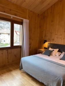 a bedroom with a bed and a large window at 42 Grados Norte Vadinia in Besande