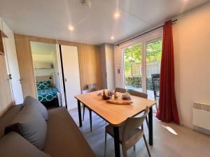 een woonkamer met een tafel en een bank bij Camping La Grappe Fleurie in Fleurie