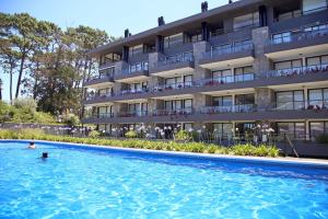 un hotel con piscina frente a un edificio en Oceana Suites en Unique, piscina climatizada, en Punta del Este