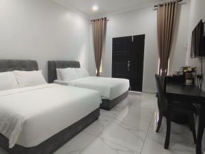 Paddy Villea Inn SPT Penang في Permatang Pauh: غرفة فندقية بسريرين ومكتب وبيانو