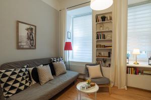Magica - Cosy Apartment in the heart of Budapest في بودابست: غرفة معيشة مع أريكة وطاولة