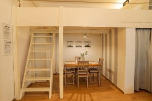 a dining room with a table and a loft bed at Magica - Cosy Apartment in the heart of Budapest in Budapest