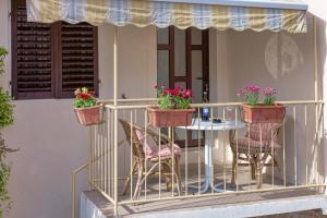 a balcony with a table and chairs and flowers at Guesthouse Wish in Stari Grad