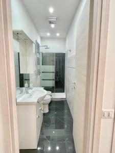 Baño blanco con lavabo y aseo en Casa vacanza l’archetto, en Genzano di Roma