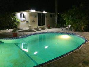 una piscina frente a una casa por la noche en 3 bedrooms villa with sea view private pool and furnished garden at Sosua 1 km away from the beach, en Sosúa