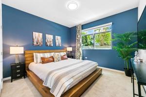 a blue bedroom with a bed and a window at Beverly Grove Chic City Oasis 2 BR Apt with Den 138 in Los Angeles