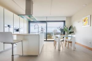 a kitchen with white cabinets and a table and chairs at Suite en el Faro de Hondarribia, con vistas in Hondarribia