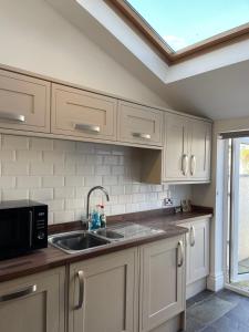 a kitchen with a sink and a microwave at Heart of Cockermouth Gem 4 bedrooms 6 beds 2 bathrooms in Cockermouth
