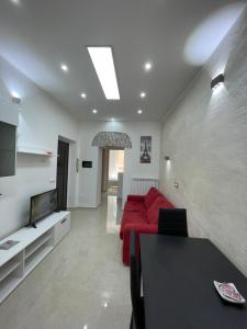 a living room with a red couch and a tv at Casa vacanza l’archetto in Genzano di Roma