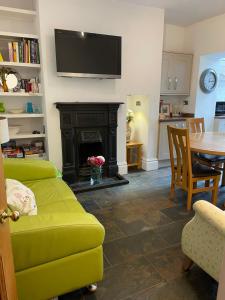 a living room with a green couch and a fireplace at Heart of Cockermouth Gem 4 bedrooms 6 beds 2 bathrooms in Cockermouth