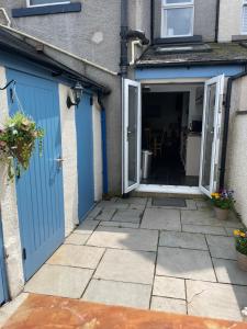 - une entrée à une maison dotée de portes bleues et d'une terrasse dans l'établissement Heart of Cockermouth Gem 4 bedrooms 6 beds 2 bathrooms, à Cockermouth